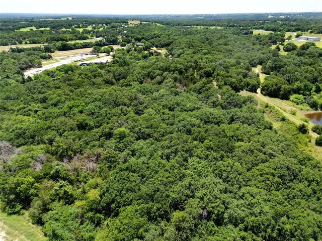 an aerial view of residential houses with outdoor space and trees