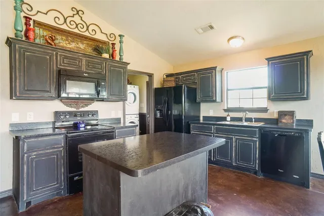 a kitchen with stainless steel appliances granite countertop a sink a stove and refrigerator
