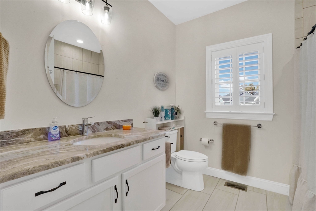 48 Liberty Lane Enfield, CT 06082 - Photo 9 of 32 a bathroom with a granite countertop toilet a sink and a mirror