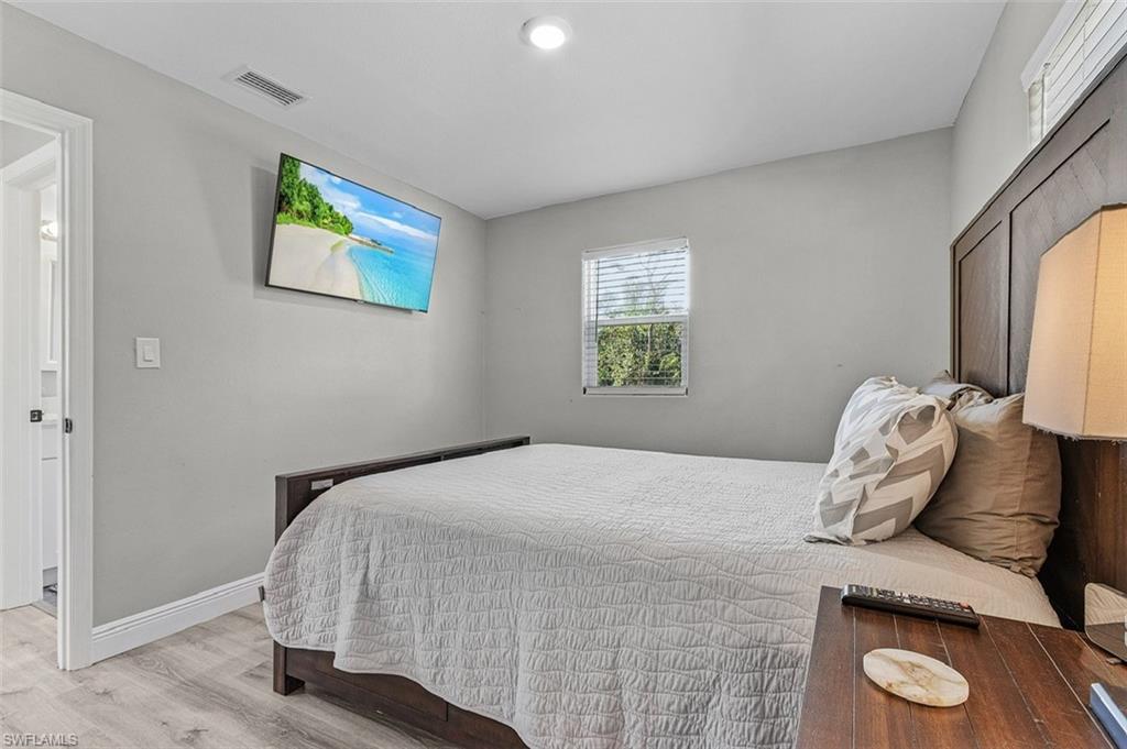 16075 Quail Trail Bokeelia, FL 33922 - Photo 16 of 24 a bedroom with a bed and painting on the wall