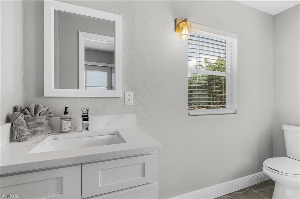 16075 Quail Trail Bokeelia, FL 33922 - Photo 18 of 24 a bathroom with a sink a toilet and a window