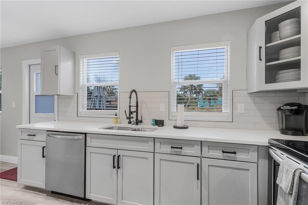 16075 Quail Trail Bokeelia, FL 33922 - Photo 19 of 24 a kitchen with stainless steel appliances white cabinets and a window