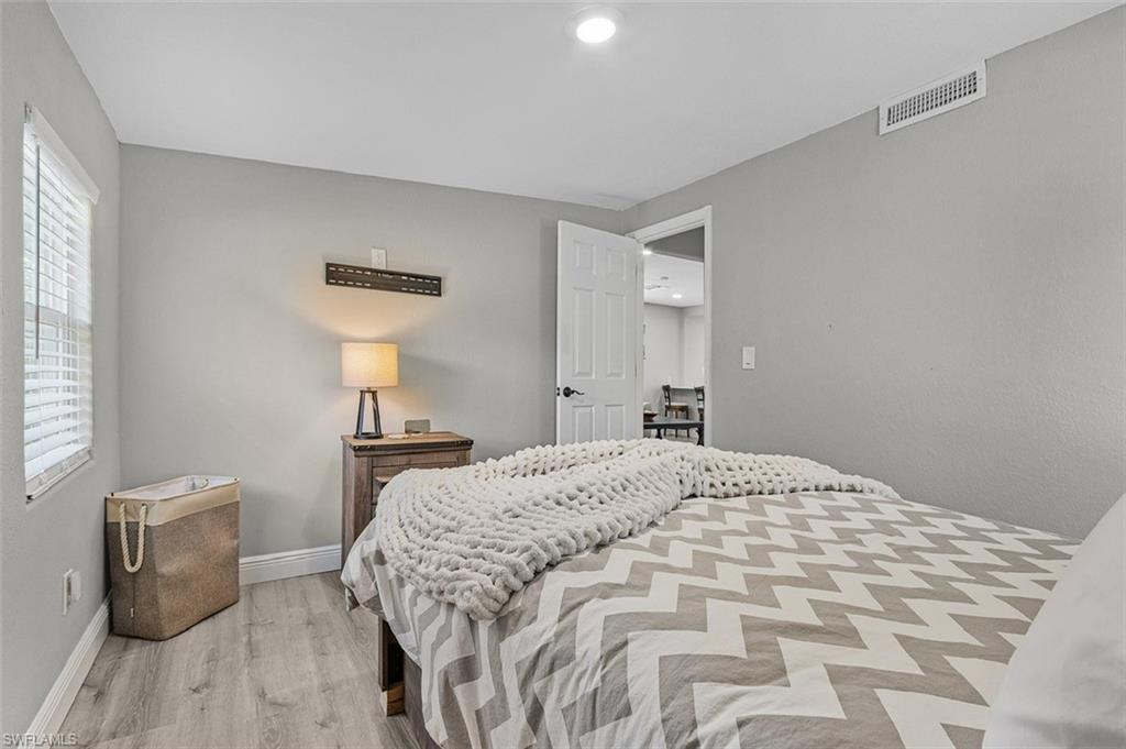 16075 Quail Trail Bokeelia, FL 33922 - Photo 9 of 24 a bedroom with a bed and a lamp