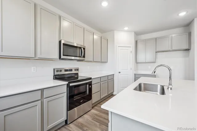 a kitchen with stainless steel appliances granite countertop white cabinets a sink and dishwasher