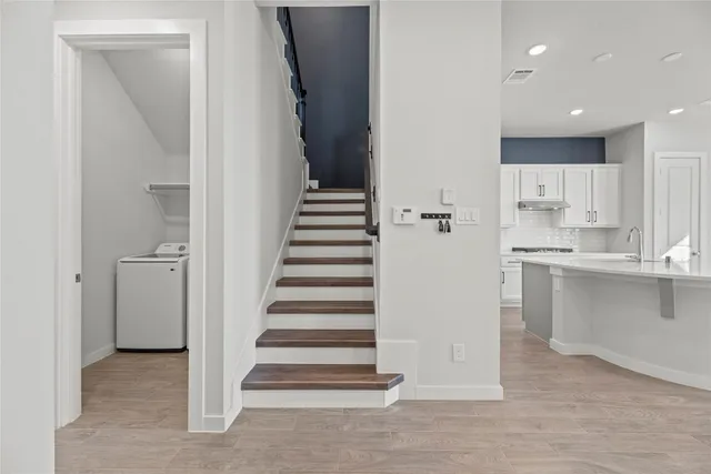 a view of a kitchen with wooden floor and electronic appliances
