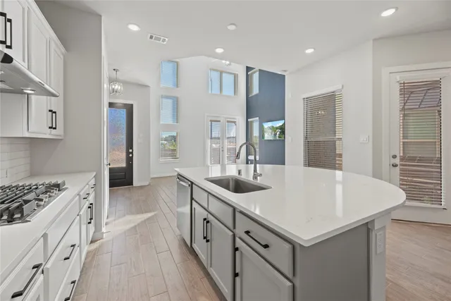 a kitchen that has a sink a stove and chairs