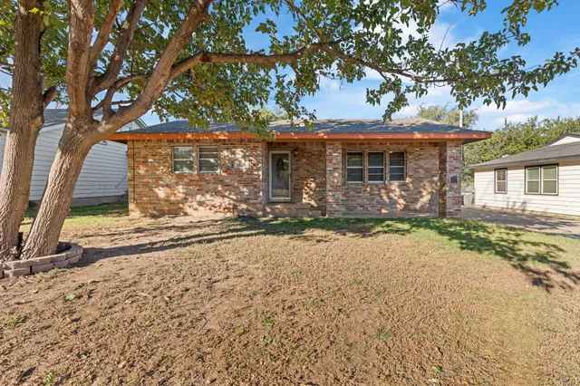 front view of a house with a large tree