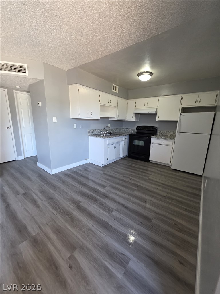1089 East Desert Inn Road, Unit 3 Las Vegas, NV 89109 - Photo 3 of 15 A well-equipped kitchen offers ample cabinet space and modern vinyl plank flooring.