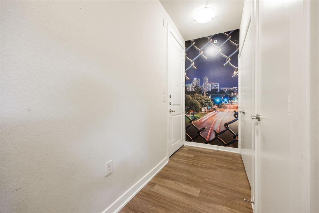 1900 Barton Springs Road, Unit 3013 Austin, TX 78704 - Photo 2 of 27 A striking wall mural with a city view adds unique character to this entry with hardwood flooring.