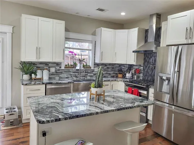 a kitchen with stainless steel appliances granite countertop a sink refrigerator and microwave