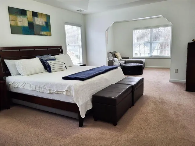 a large bedroom with a bed and wooden floor