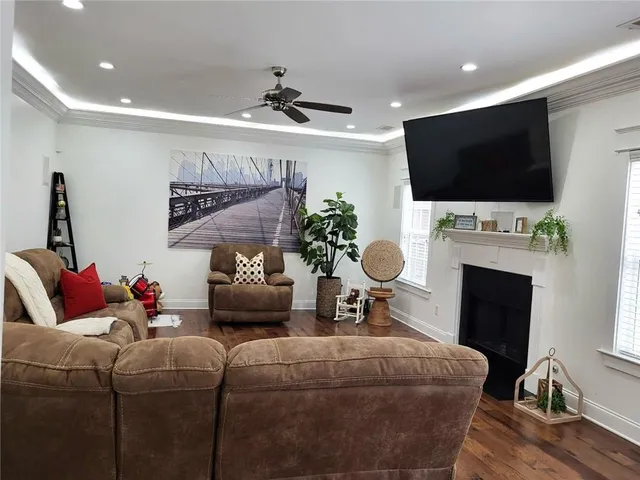 a living room with furniture a flat screen tv and a fireplace