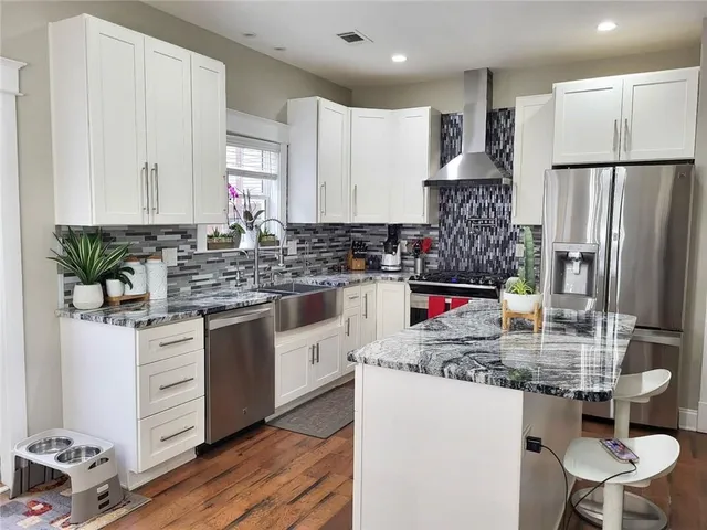 a kitchen with stainless steel appliances granite countertop a stove refrigerator sink and cabinets