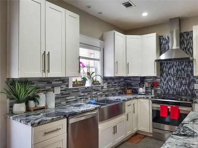 a kitchen with stainless steel appliances granite countertop a sink stove and cabinets
