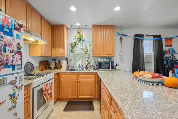 a kitchen that has a lot of cabinets in it and wooden floor