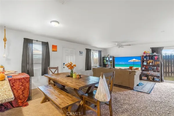 a living room with a couch and a dining table with wooden floor