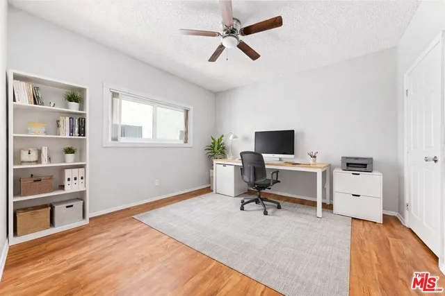 a view of a workspace with furniture and a window