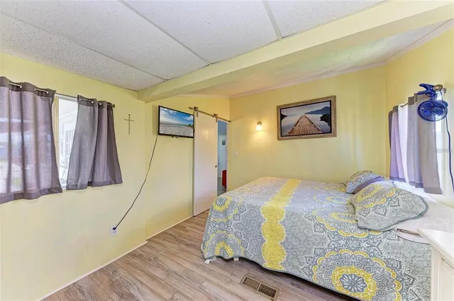 a bedroom with a bed and wooden floor