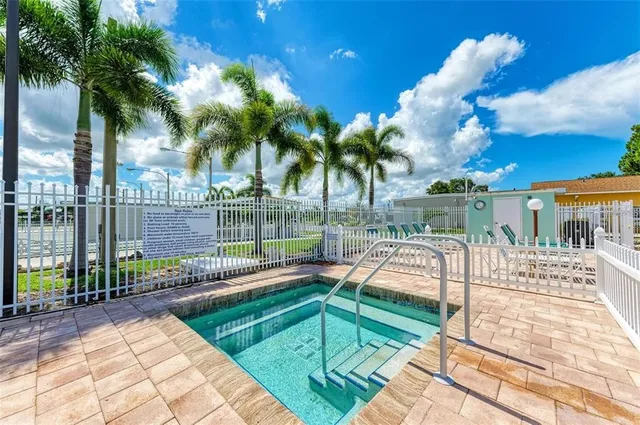 a view of a swimming pool with a patio and a yard