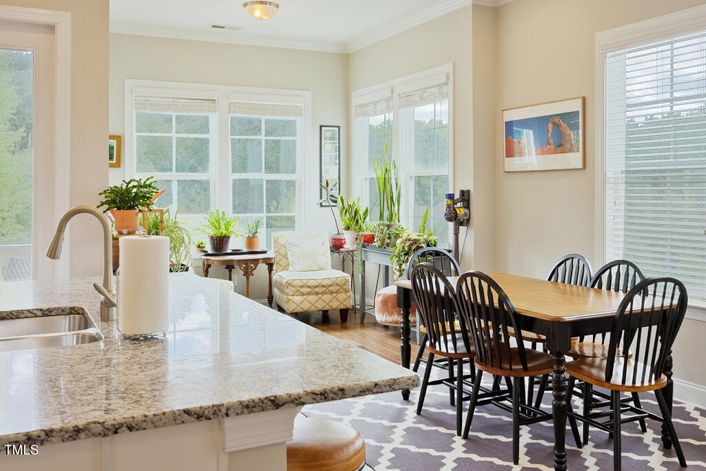 910 Wake Towne Drive Raleigh, NC 27609 - Photo 13 of 45 a view of a dining room and livingroom with furniture wooden floor and a garden view