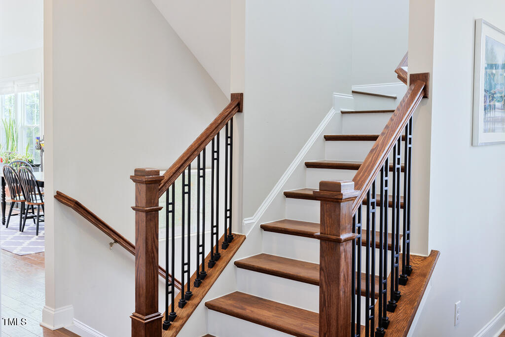 910 Wake Towne Drive Raleigh, NC 27609 - Photo 17 of 45 a view of staircase with wooden floor and white walls