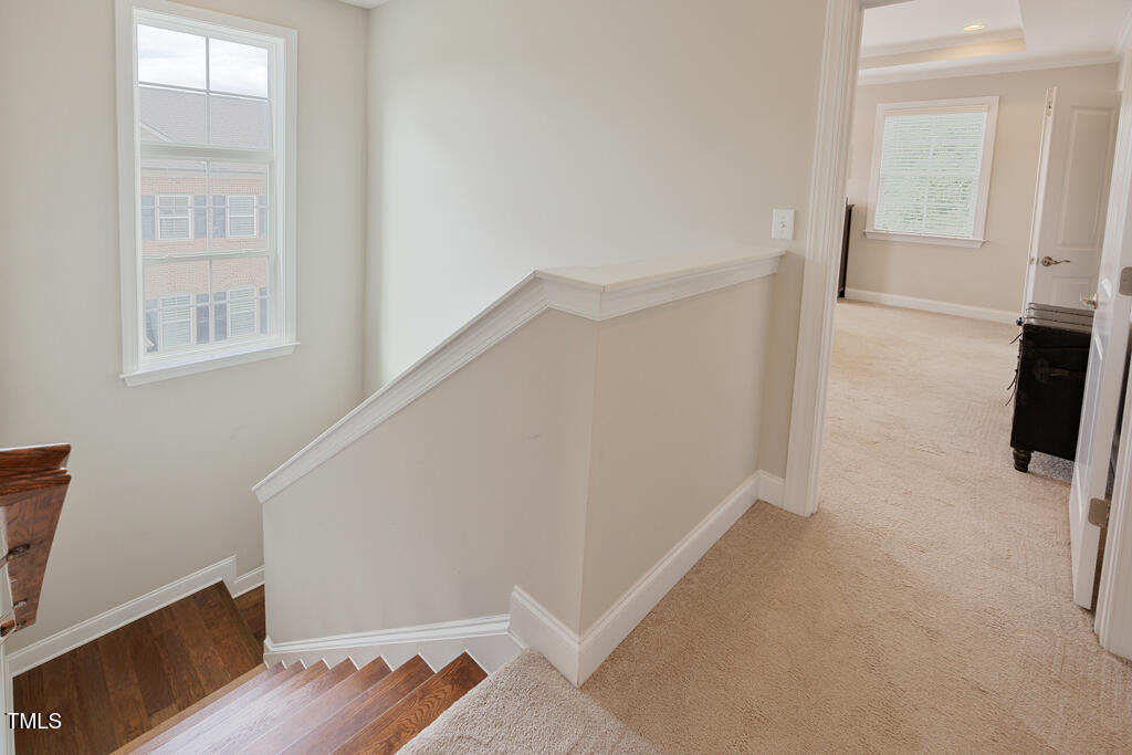 910 Wake Towne Drive Raleigh, NC 27609 - Photo 18 of 45 a view of hallway with window and wooden floor