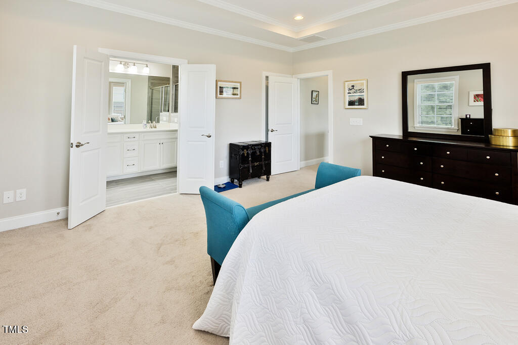 910 Wake Towne Drive Raleigh, NC 27609 - Photo 21 of 45 a bedroom with a bed and a chandelier