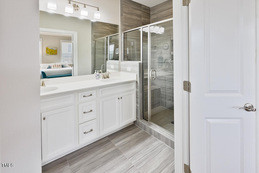 910 Wake Towne Drive Raleigh, NC 27609 - Photo 22 of 45 a bathroom with a double vanity sink and mirror