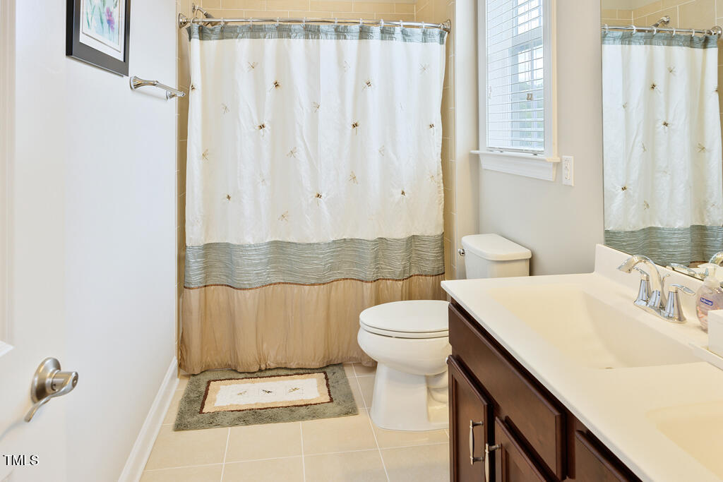 910 Wake Towne Drive Raleigh, NC 27609 - Photo 29 of 45 a bathroom with a sink a toilet and shower curtain