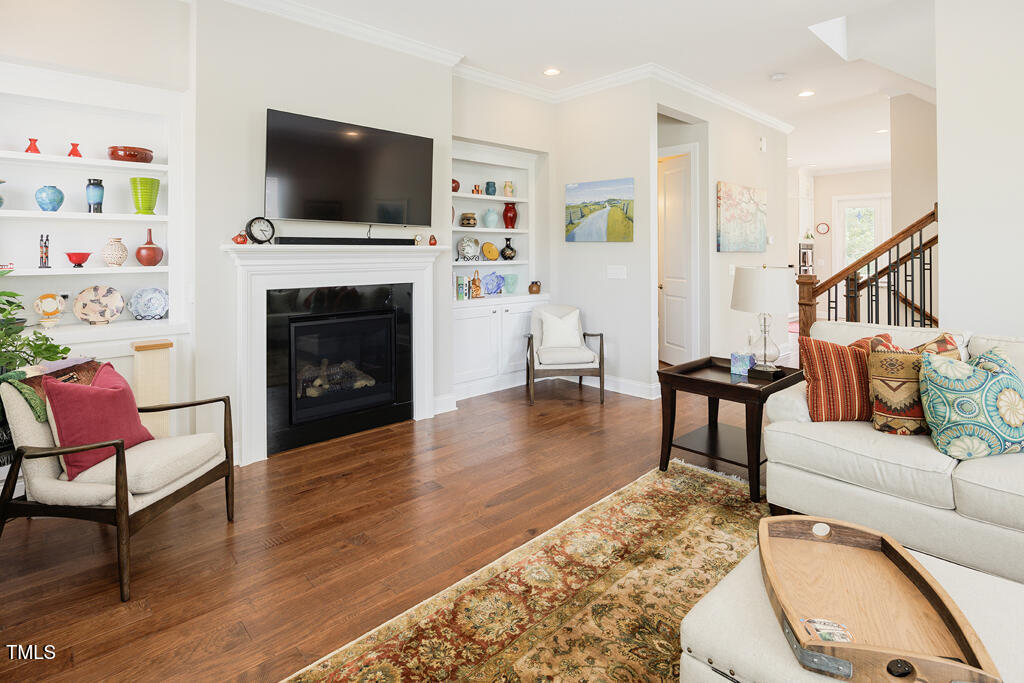 910 Wake Towne Drive Raleigh, NC 27609 - Photo 4 of 45 a living room with furniture a flat screen tv and a fireplace