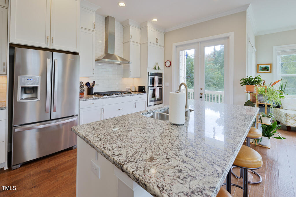 910 Wake Towne Drive Raleigh, NC 27609 - Photo 9 of 45 a kitchen with stainless steel appliances granite countertop sink stove refrigerator and wooden floor