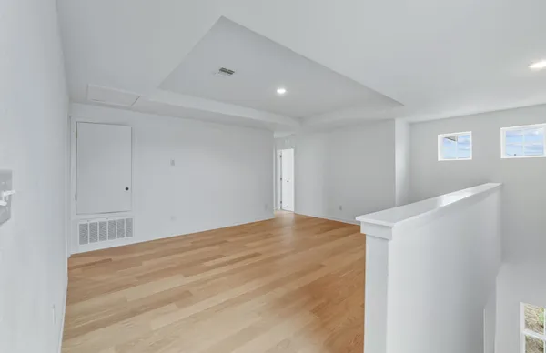 a view of empty room with wooden floor