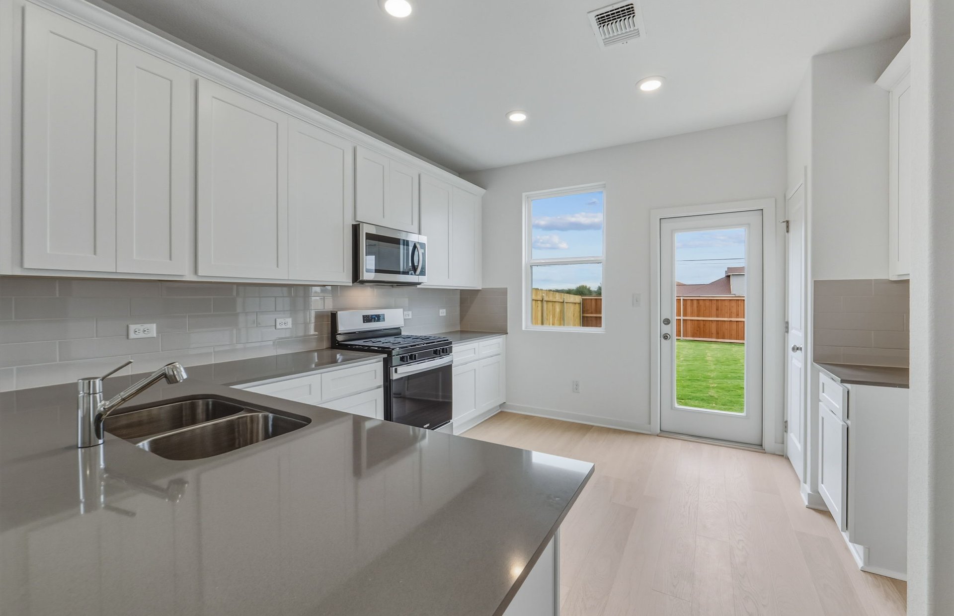 341 Sullivan Way Elgin, TX 78621 - Photo 3 of 23 a kitchen with stainless steel appliances granite countertop a refrigerator sink and stove
