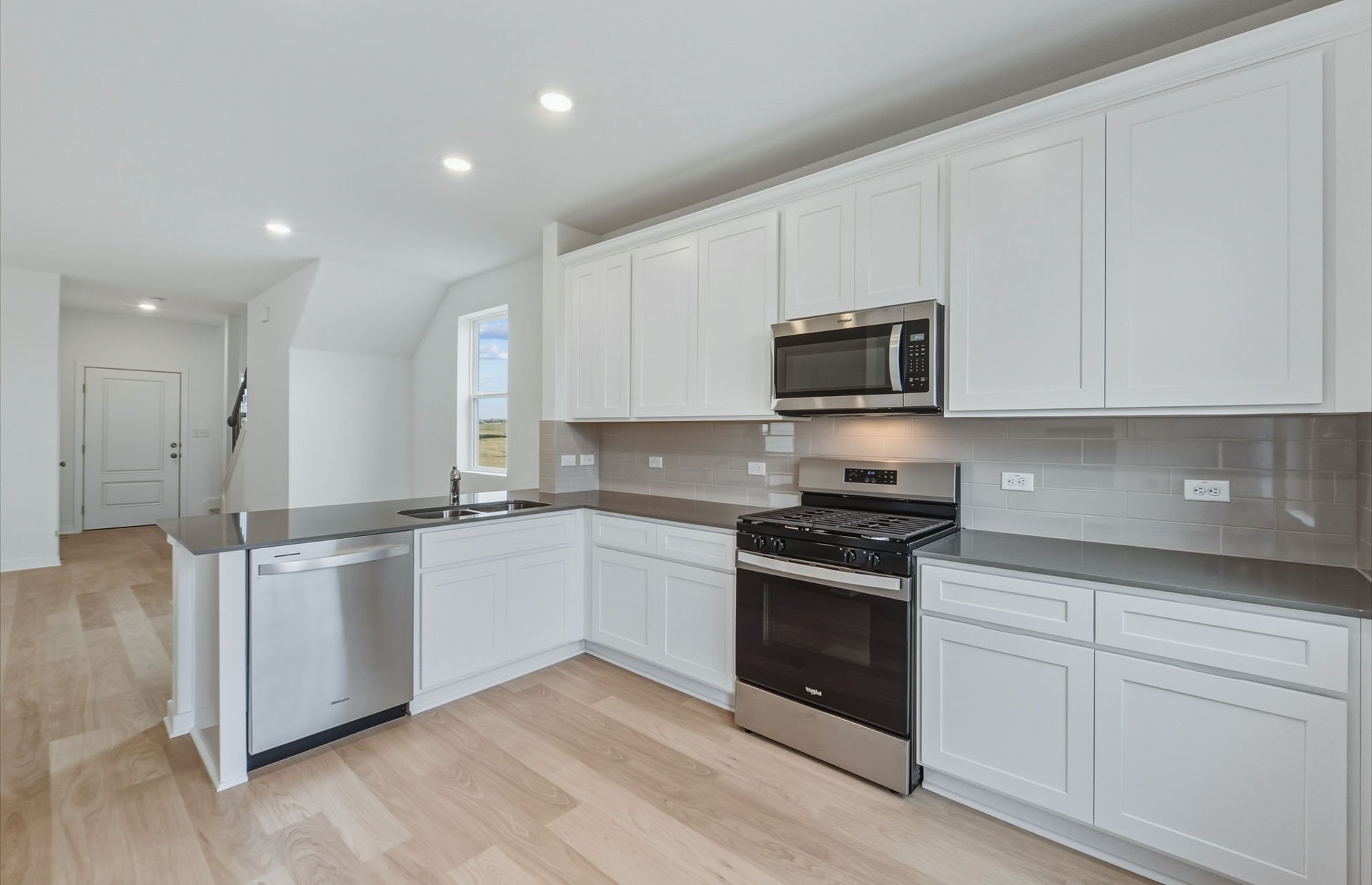 341 Sullivan Way Elgin, TX 78621 - Photo 4 of 23 a kitchen with stainless steel appliances granite countertop a stove a sink and a microwave