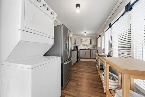 a kitchen with stainless steel appliances granite countertop a refrigerator a stove and a wooden floors
