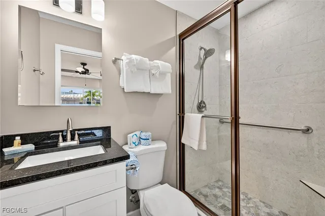 a bathroom with a granite countertop sink toilet and shower