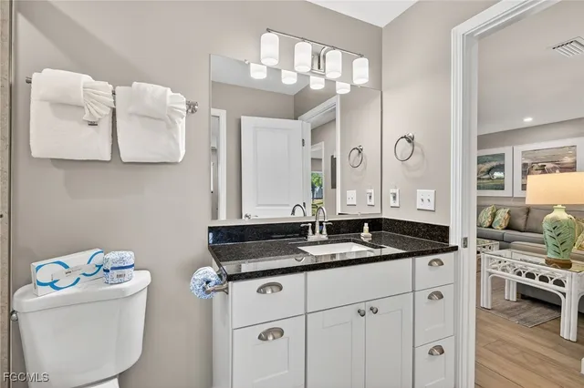 a bathroom with a granite countertop sink and a mirror