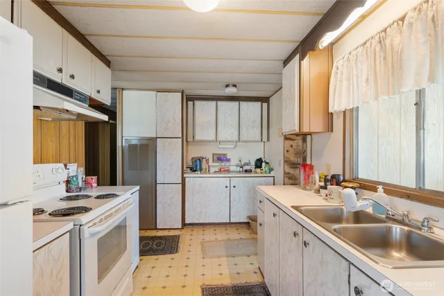 a kitchen with a sink a stove a refrigerator and cabinets