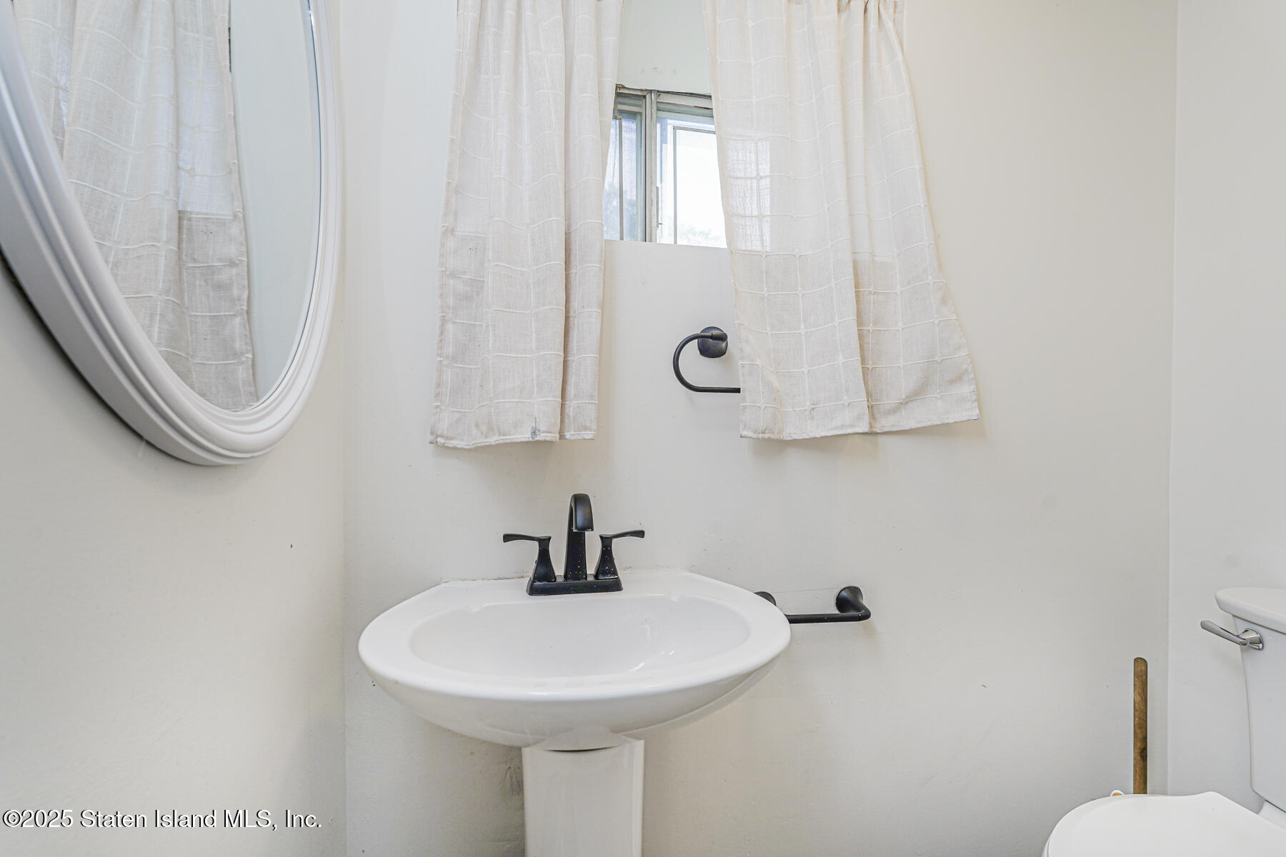 622 Barlow Avenue Staten Island, NY 10312 - Photo 16 of 27 a bathroom with a sink a toilet and mirror