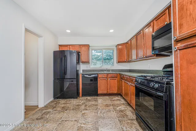 a kitchen with stainless steel appliances granite countertop a refrigerator stove top oven and sink