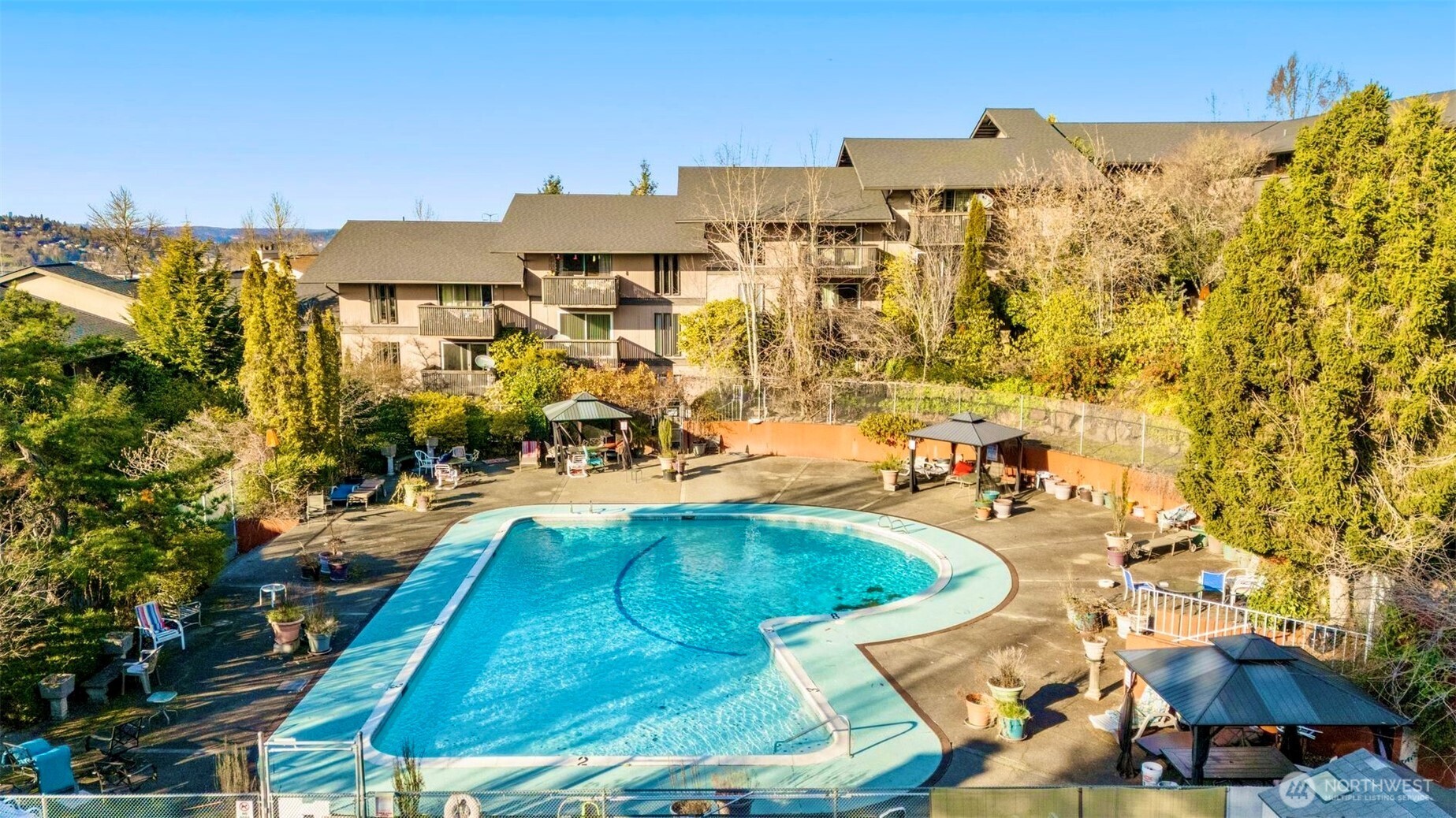 an aerial view of residential houses with outdoor space and trees