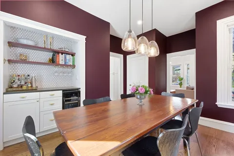 a view of a dining room with furniture a chandelier and wooden floor