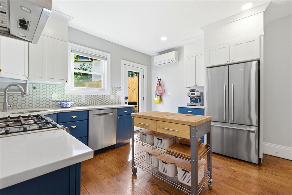 101 Forbes Street Boston, MA 02130 - Photo 14 of 38 a kitchen with kitchen island a counter top space a sink a refrigerator and a window