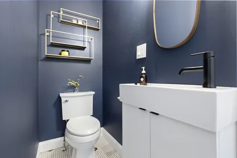 a bathroom with a toilet a sink and mirror