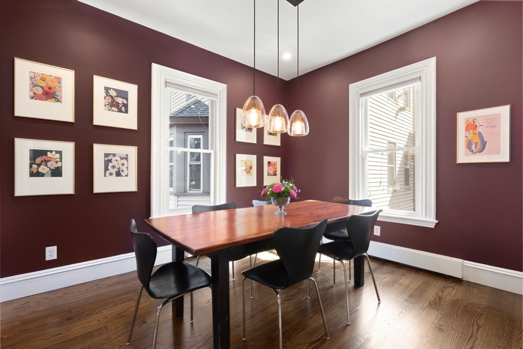 101 Forbes Street Boston, MA 02130 - Photo 9 of 38 a dining room with wooden floor a chandelier a wooden table and chairs