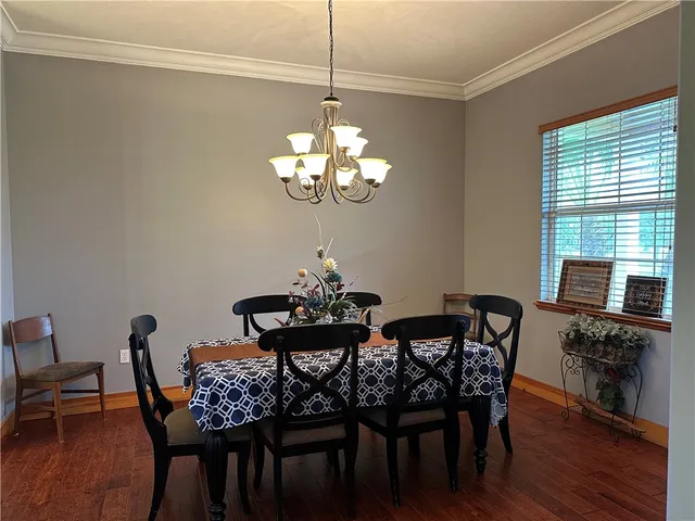 a dining room with furniture a chandelier and wooden floor