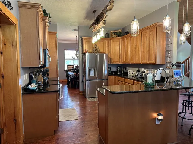 a kitchen with stainless steel appliances granite countertop a refrigerator a stove and a sink