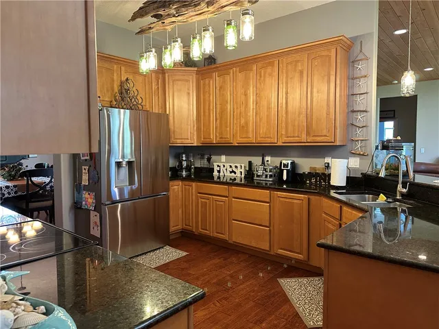 a kitchen with stainless steel appliances granite countertop a sink a stove and a refrigerator