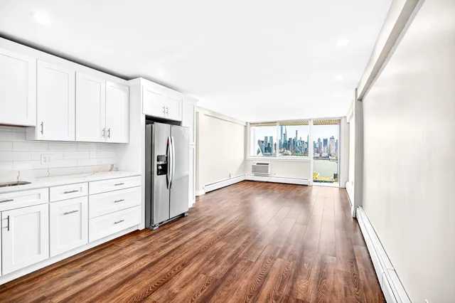 a kitchen with stainless steel appliances granite countertop a refrigerator stove and white cabinets