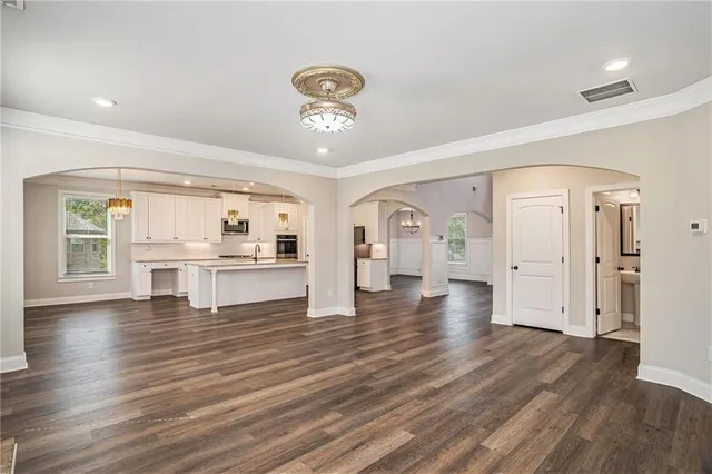 a view of open kitchen with white cabinets and wooden floor
